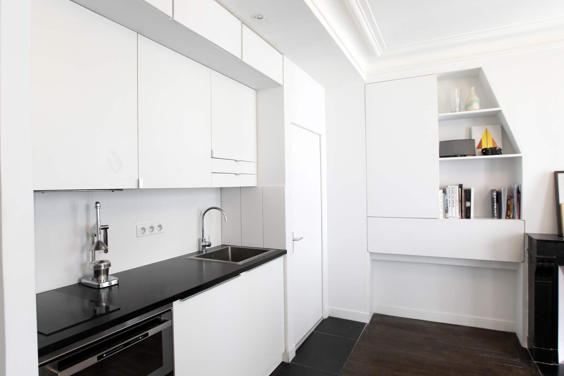 Appartement Oasis à Paris, séjour rénové, cheminée en marbre noir et rangements dessinés