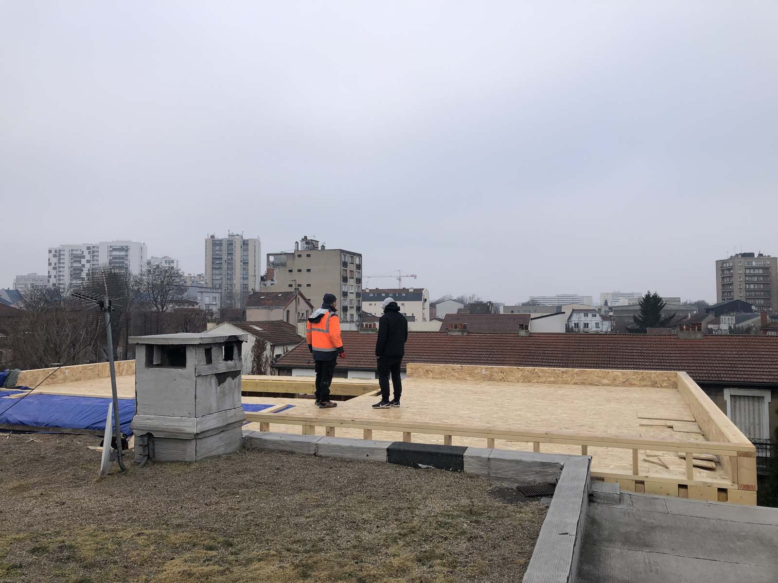 Plancher haut posé au-dessus des toits, deux compagnons, Aubervilliers en fond