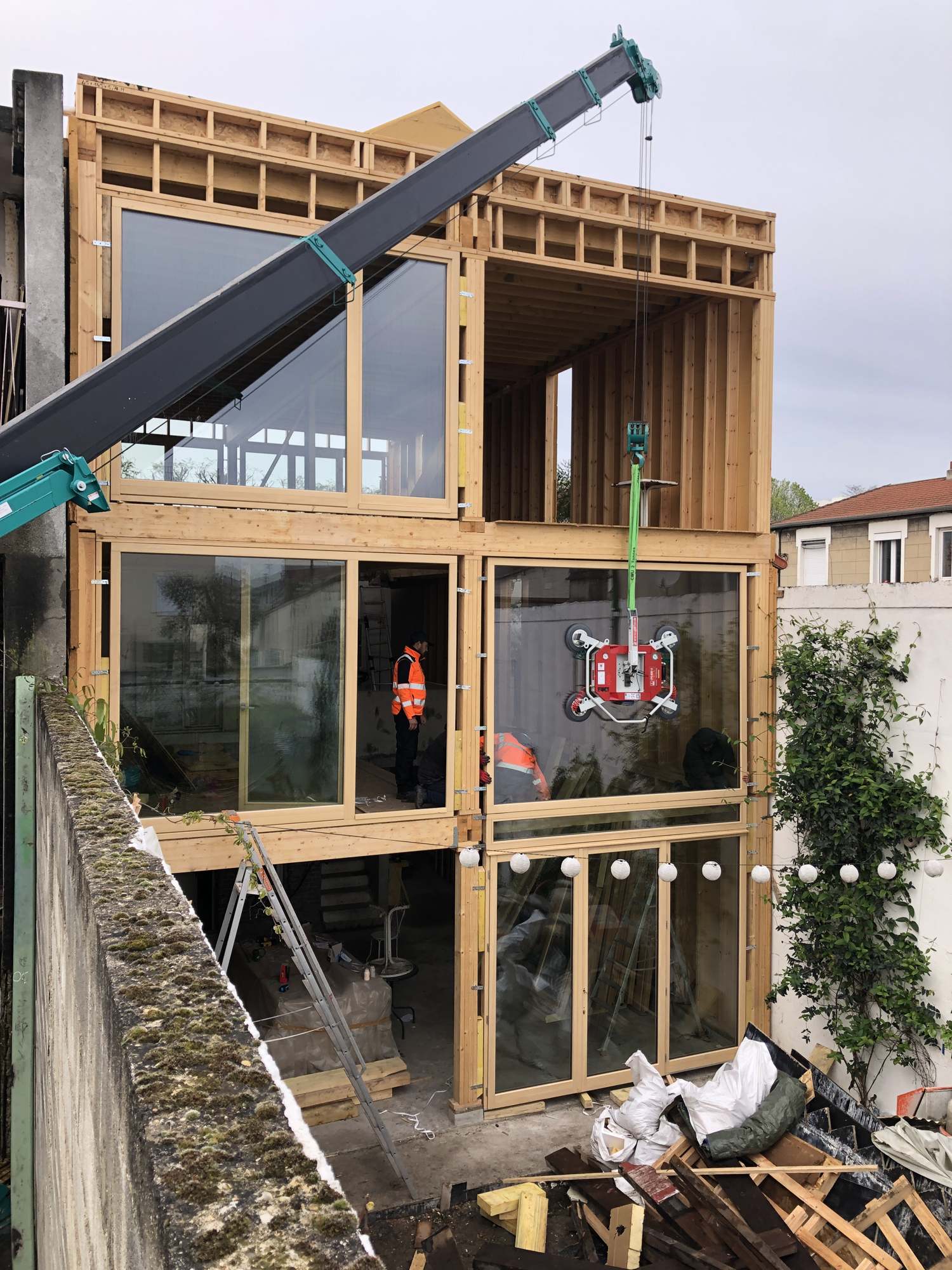 Pose d’un vitrage à la grue araignée sur la façade ossature bois