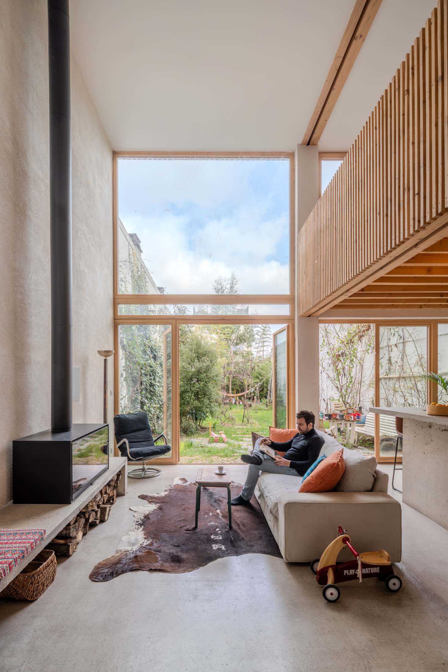 Le séjour en double hauteur, béton brut et mezzanine bois, photographie Antoine Duhamel