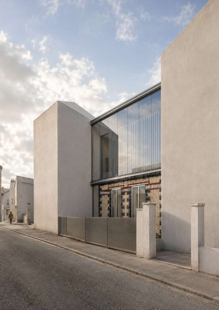 Surélévation du 26 bis rue Lénine à Bagnolet vue depuis la rue, verrière sur le soubassement en brique et meulière