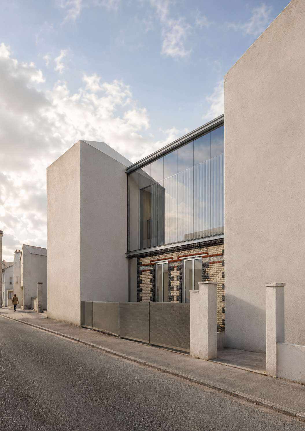 Surélévation du 26 bis rue Lénine à Bagnolet vue depuis la rue, verrière sur le soubassement en brique et meulière