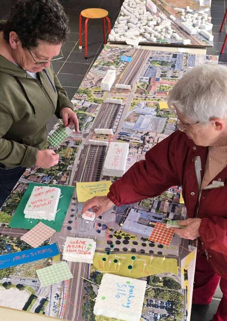 Habitants travaillant sur la maquette collective du centre-ville de Trappes