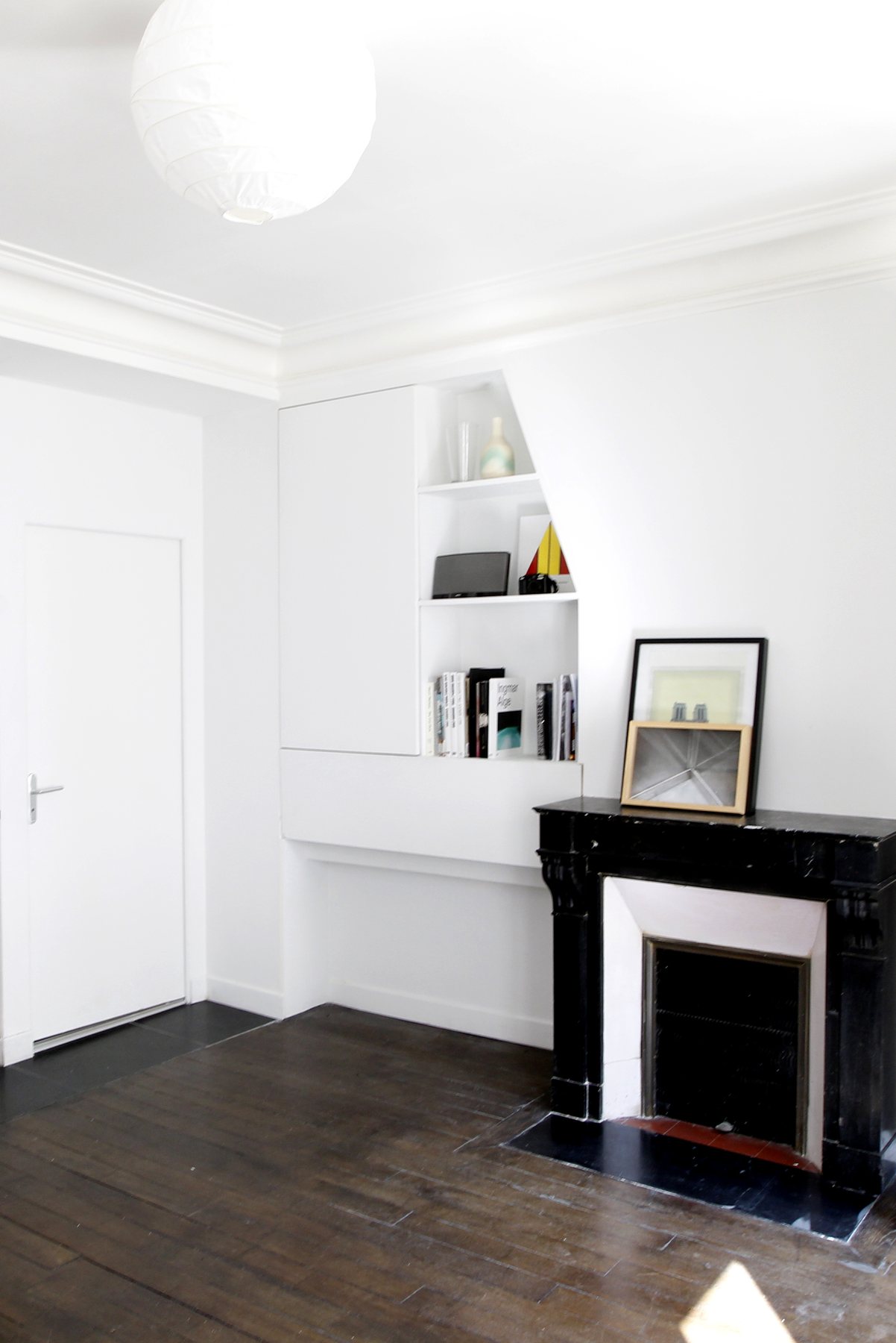 Appartement Oasis à Paris, séjour rénové, cheminée en marbre noir et rangements dessinés