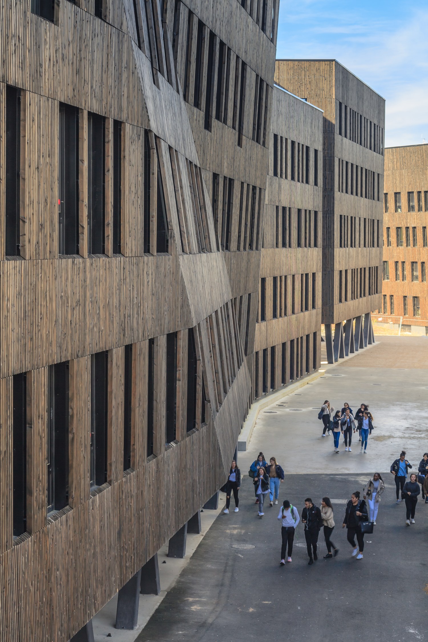 Des élèves longent la façade bois